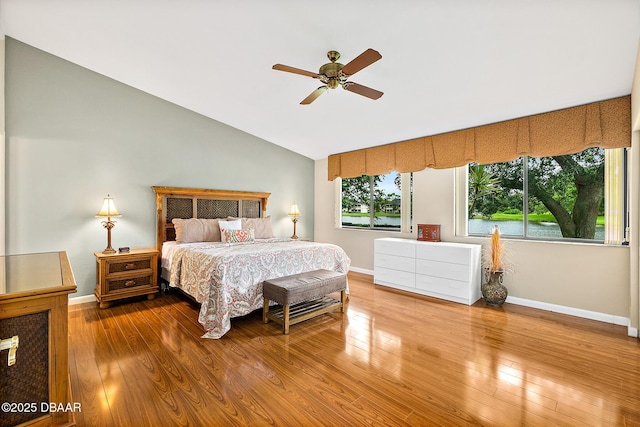 bedroom with ceiling fan, wood-type flooring, and vaulted ceiling