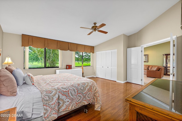 bedroom with hardwood / wood-style flooring, ceiling fan, vaulted ceiling, and a closet