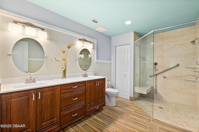 bathroom with vanity, toilet, and tiled shower