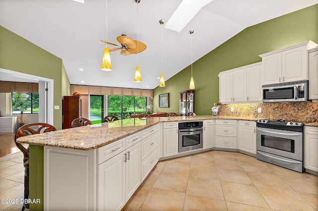 kitchen with white cabinetry, appliances with stainless steel finishes, kitchen peninsula, and hanging light fixtures