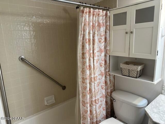 full bathroom featuring shower / bath combo with shower curtain, vanity, and toilet