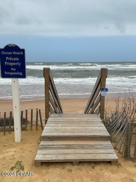 view of home's community featuring a beach view and a water view