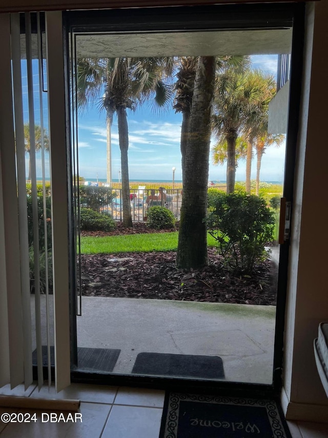 entryway with a water view, a healthy amount of sunlight, and tile patterned floors