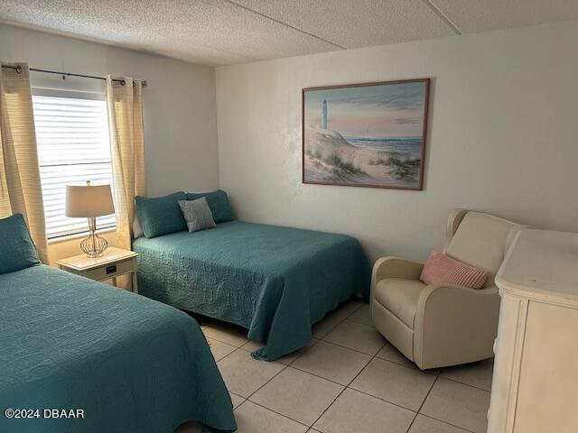 bedroom with a textured ceiling and light tile patterned floors