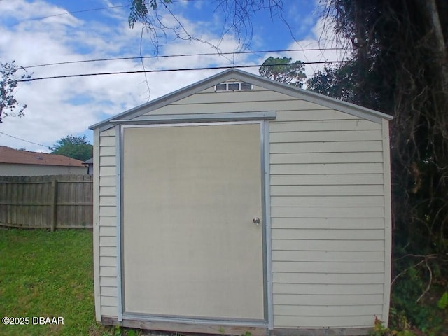 view of shed featuring fence