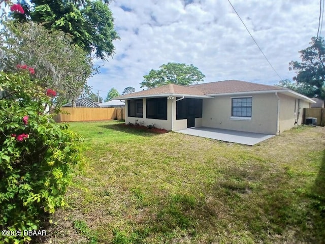 rear view of house featuring a yard, a patio, stucco siding, and fence