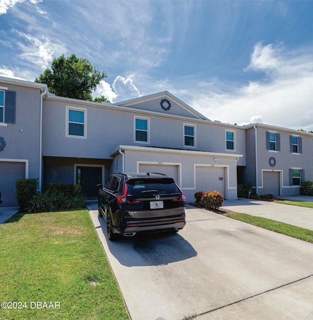 townhome / multi-family property with a garage and a front yard