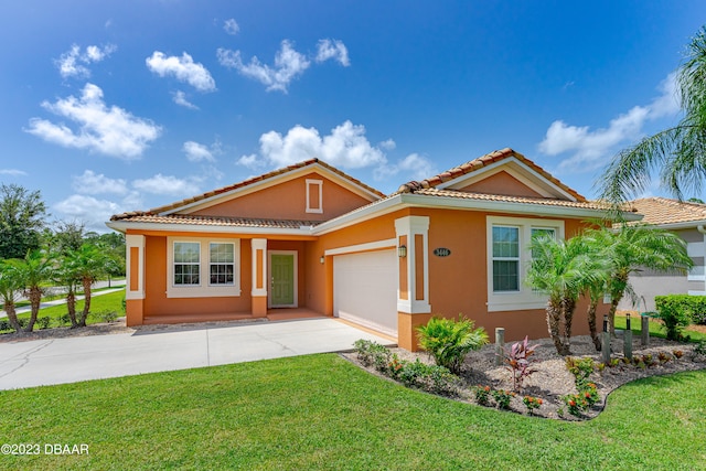 mediterranean / spanish-style house featuring a garage and a front yard