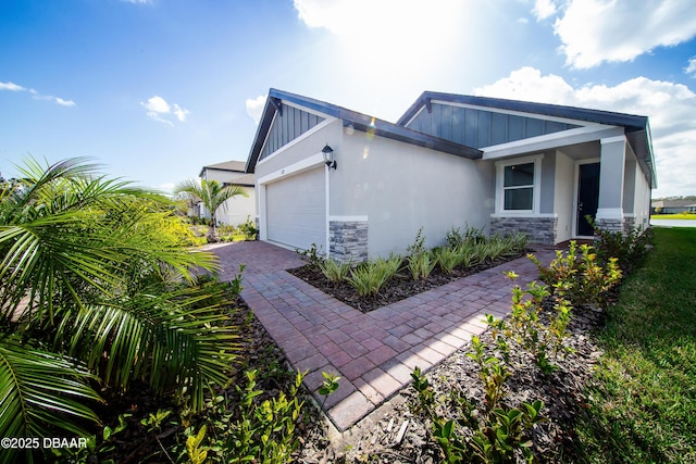 129 Lost Ball Dr, Daytona Beach, FL 32124 - view of home's exterior featuring stone siding, an attached garage, board and batten siding, and decorative driveway
