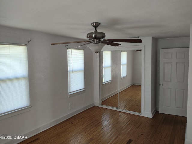 unfurnished bedroom with visible vents, baseboards, hardwood / wood-style flooring, a closet, and a ceiling fan