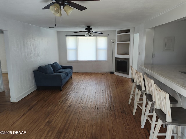 sitting room featuring visible vents, baseboards, ceiling fan, dark wood finished floors, and built in features