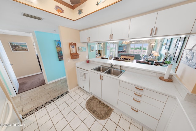 kitchen featuring white cabinets, light tile patterned flooring, a chandelier, and sink