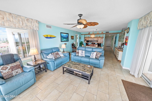 living room with light tile patterned flooring, a textured ceiling, and ceiling fan