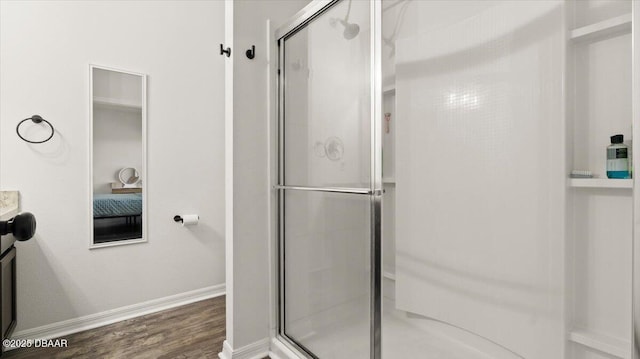 bathroom with a shower stall, vanity, baseboards, and wood finished floors