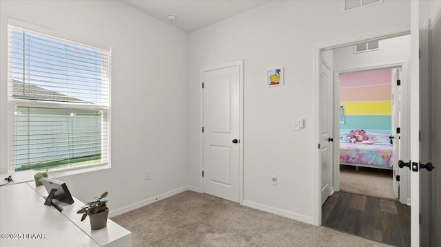 carpeted home office with baseboards and visible vents