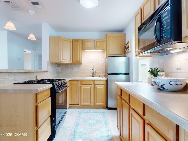 823 E 10th Ave, New Smyrna Beach, FL 32169 - kitchen with black appliances, light brown cabinets, decorative backsplash, light countertops, and pendant lighting