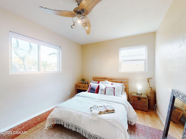 823 E 10th Ave, New Smyrna Beach, FL 32169 - bedroom with multiple windows, a ceiling fan, a fireplace, and wood finished floors