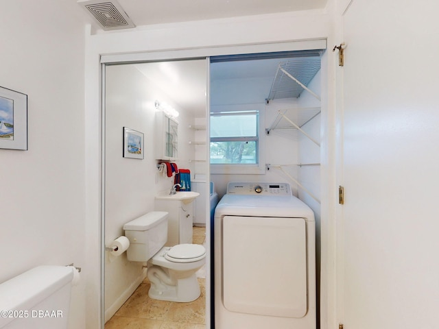 823 E 10th Ave, New Smyrna Beach, FL 32169 - bathroom with washer / dryer, vanity, and tile patterned floors