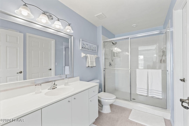 bathroom featuring toilet, vanity, tile patterned floors, and a shower with door