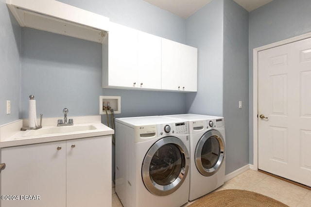 washroom featuring cabinets, light tile patterned flooring, sink, and independent washer and dryer