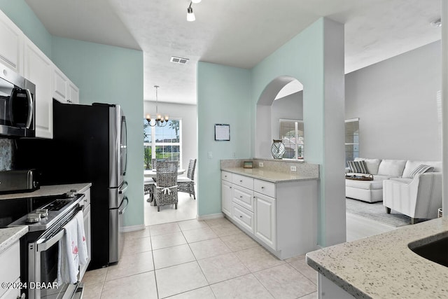 kitchen featuring white cabinetry, light stone countertops, a notable chandelier, and white range with electric stovetop