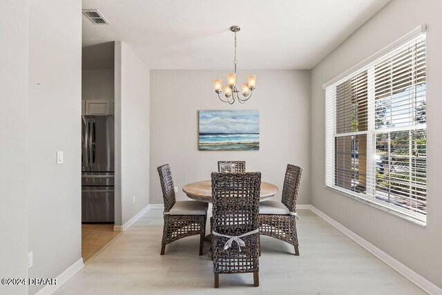 dining area featuring a notable chandelier and light hardwood / wood-style floors