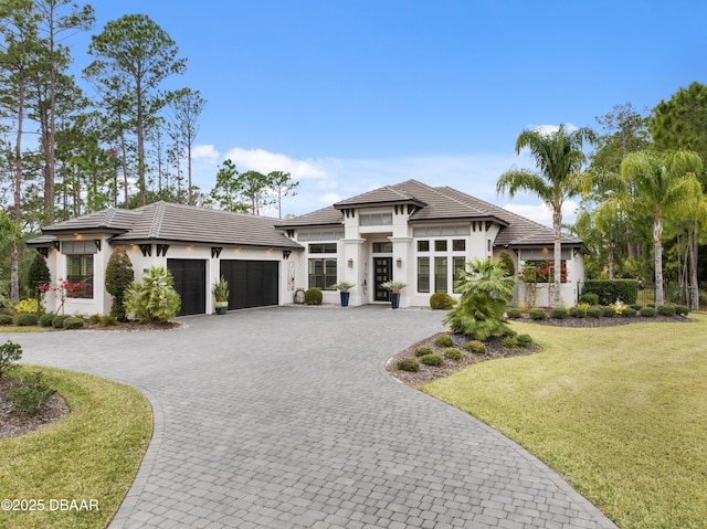 prairie-style home with a garage and a front lawn