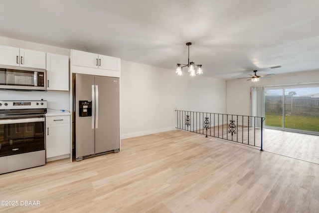 kitchen with light hardwood / wood-style flooring, pendant lighting, stainless steel appliances, ceiling fan with notable chandelier, and white cabinets