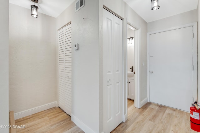 hallway featuring sink and light hardwood / wood-style flooring