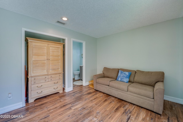 113 Club House Blvd, New Smyrna Beach, FL 32168 - living room with baseboards, visible vents, wood finished floors, and a textured ceiling