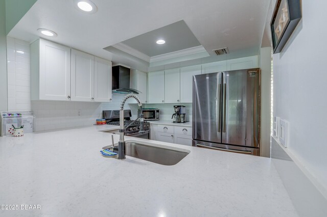 113 Club House Blvd, New Smyrna Beach, FL 32168 - kitchen with wall chimney range hood, a raised ceiling, white cabinetry, and appliances with stainless steel finishes