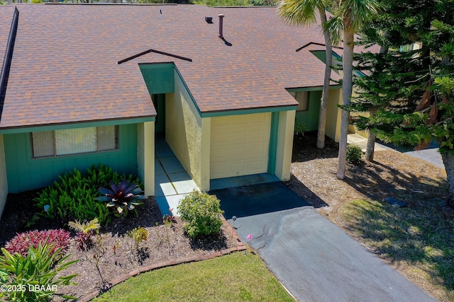 113 Club House Blvd, New Smyrna Beach, FL 32168 - view of front of home with a shingled roof, driveway, stucco siding, and an attached garage