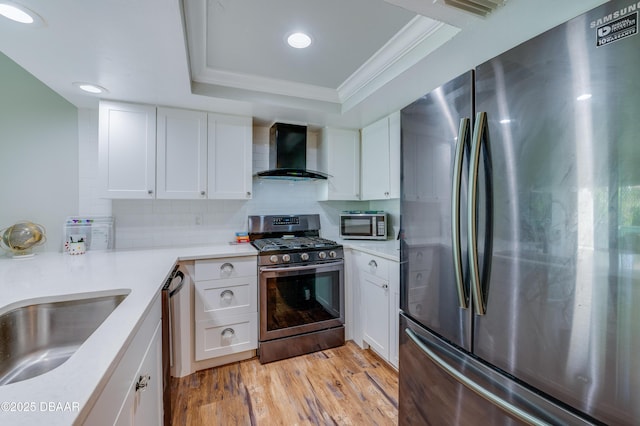 113 Club House Blvd, New Smyrna Beach, FL 32168 - kitchen featuring crown molding, wall chimney exhaust hood, stainless steel appliances, light wood-type flooring, and a tray ceiling