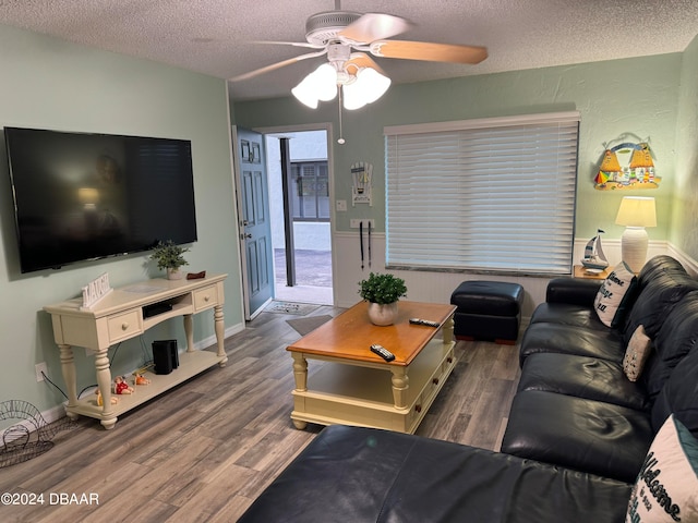 living room featuring dark hardwood / wood-style flooring, a textured ceiling, and ceiling fan