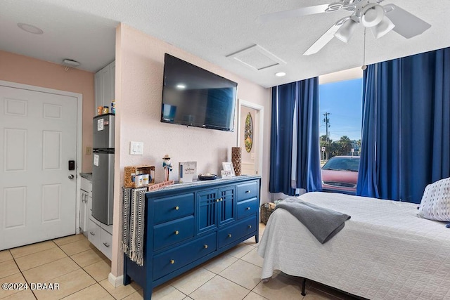 bedroom with ceiling fan, light tile patterned floors, a textured ceiling, and water heater