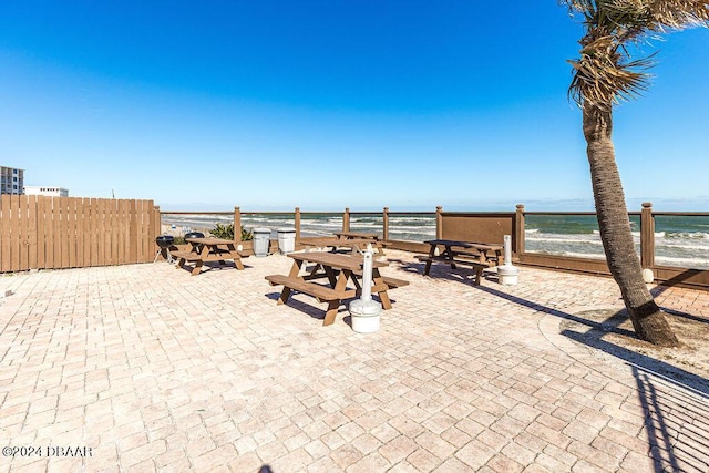 view of patio featuring a beach view and a water view