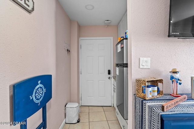 washroom with light tile patterned flooring and water heater