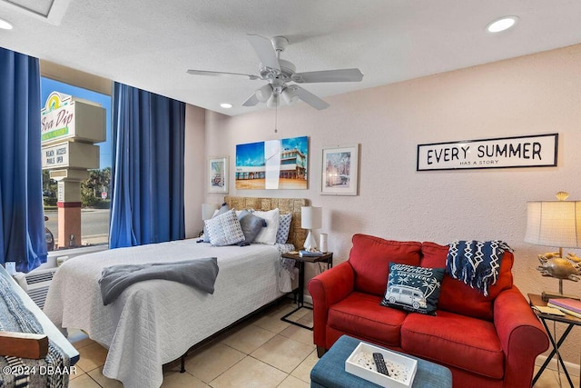 bedroom featuring light tile patterned floors, a textured ceiling, and ceiling fan