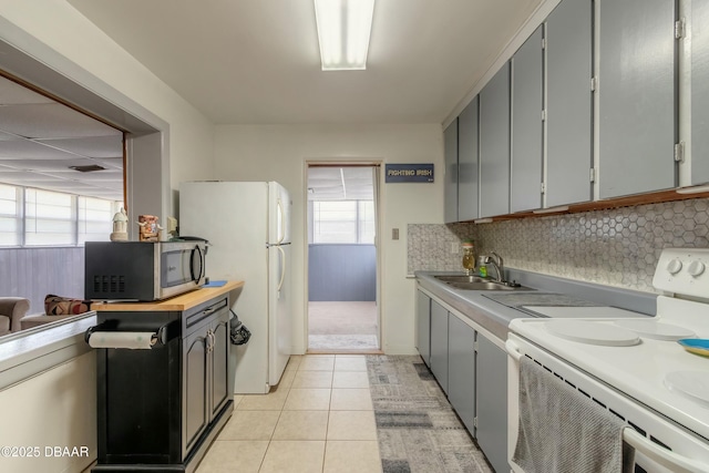 kitchen featuring white appliances, gray cabinetry, sink, and light tile patterned floors