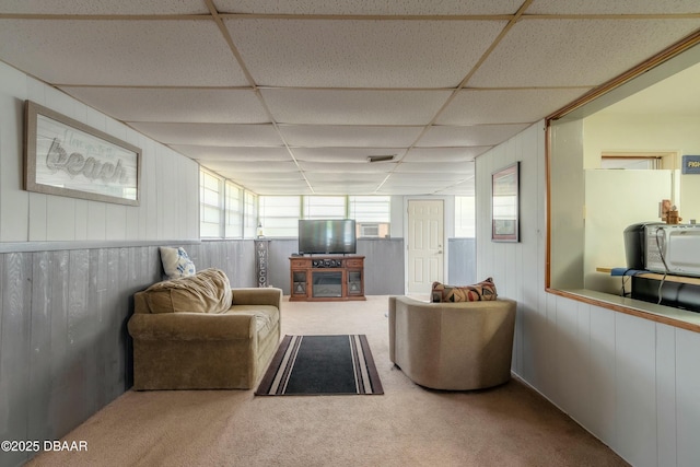 carpeted living room with a paneled ceiling