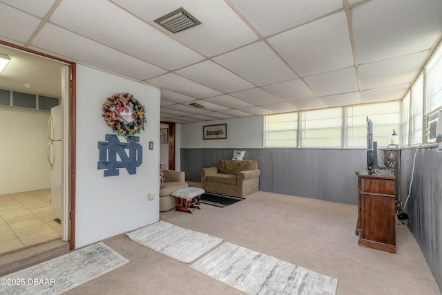 living room featuring a drop ceiling and carpet flooring