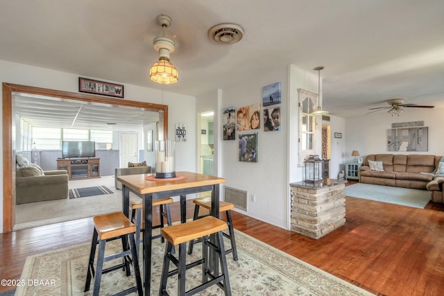 dining space with hardwood / wood-style floors and ceiling fan