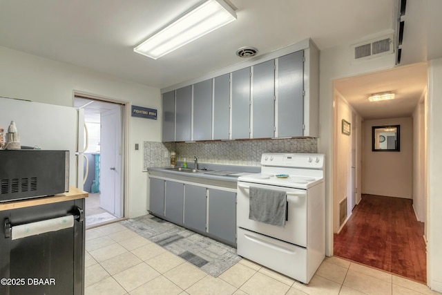 kitchen with sink, light tile patterned floors, decorative backsplash, white range with electric stovetop, and gray cabinetry