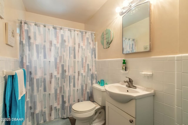 bathroom featuring toilet, walk in shower, tile walls, and vanity