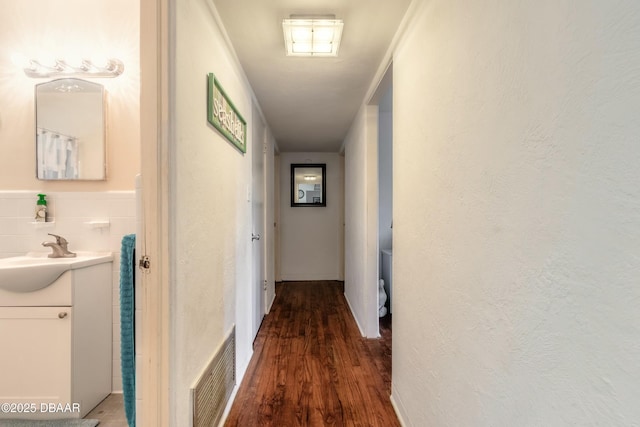 hall featuring crown molding, dark hardwood / wood-style floors, and sink