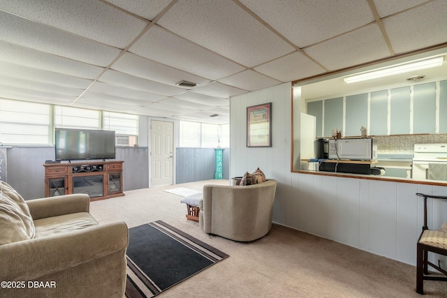 carpeted living room featuring a drop ceiling