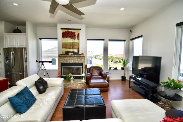 living room with a textured ceiling, ceiling fan, and dark hardwood / wood-style floors