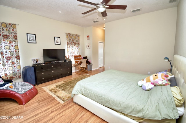 bedroom featuring ceiling fan, wood-type flooring, and a textured ceiling