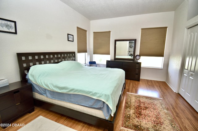 bedroom featuring a textured ceiling, light hardwood / wood-style floors, and a closet