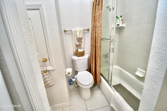 bathroom featuring tile patterned flooring, toilet, and bath / shower combo with glass door